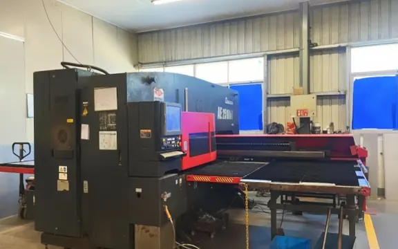 CNC turret punch creating ventilation louvers and cable entries in diesel generator enclosure panels &mdash; H&C factory