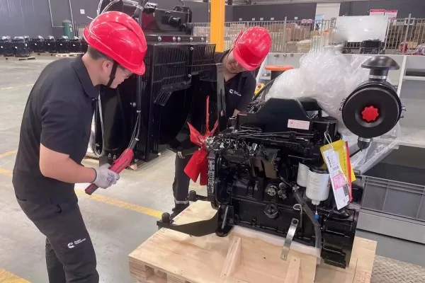 Professional technicians performing precision assembly of diesel generator components in a safe factory environment.